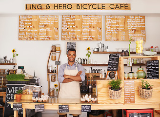 Image showing Portrait, black man and barista with arms crossed in cafe with pride for career or job. Waiter, smile and confidence of African person from Nigeria in restaurant, small business and coffee shop.