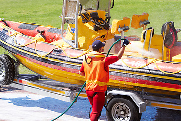 Image showing Cleaning, boat and rescue or emergency worker washing speedboat ready for search mission for an investigation. Safety, person or man coast guard employee in preparation for water service