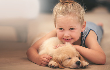 Image showing Young girl hug her puppy, relax at home and happy with sleeping golden retriever dog and child with smile. Happiness, pet care and love with female kid with her domestic animal lying on wood floor