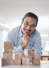 Image showing Portrait of businessman with smile, growth and blocks, thinking challenge game and design balance. Engineering, architecture and happiness, asian designer with building block problem solving games.