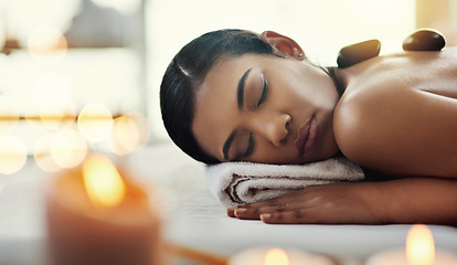 Image showing Woman, relax and sleeping on bed at spa for rock massage, skincare or beauty body treatment at resort. Calm female asleep with eyes closed and hot rocks on back in healthy physical therapy at salon