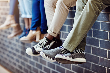 Image showing Brick wall, student feet and friends outdoor on university campus together with sneakers. Relax, urban youth and foot at college with people legs ready for education, study and shoes while sitting