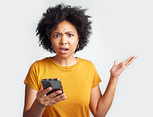 Image showing Portrait, young woman and surprised with phone on hand and omg with text or spam on social media and online news. Technology, communication and scam announcement on grey studio background.