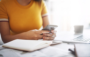 Image showing Hands, woman with a smartphone and laptop by her desk in office. Social media or communication, connectivity or networking and female worker on cellphone reading or writing an email at workplace