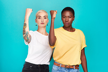 Image showing Women, fight and portrait with fist for human rights, lgbt and revolution gesture for power. Diversity and pride of young people with blue background in studio with rally, equality and protest sign