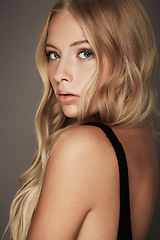 Image showing Beauty, face and portrait of a woman with makeup, cosmetics and long hair in studio. Headshot of a female aesthetic model with a skin glow, luxury skincare and seductive fashion on a grey background