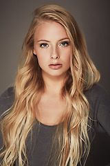 Image showing Face, beauty and portrait of a woman in studio with makeup, cosmetics and long hair. Headshot of a female aesthetic model with a natural glow, luxury skincare and seductive pose on a grey background