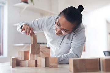 Image showing Man in office with wood block game, thinking challenge and design innovation for balance and construction. Engineering, architecture and asian designer with building blocks for problem solving games.