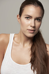 Image showing Serious woman, portrait and natural beauty in skincare or facial cosmetics against grey studio background. Isolated female person, face or model in cosmetic haircare in active sportswear on backdrop