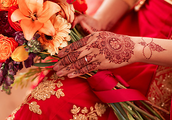 Image showing Henna, hands and Indian woman at her wedding event with flowers or bouquet for decoration or design. Luxury, marriage and traditional culture by a bride with art pattern on her hand for celebration