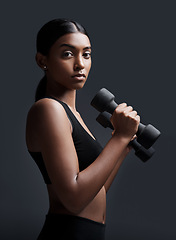 Image showing Serious, portrait and woman with dumbbells for workout in studio isolated on a black background. Strong, bodybuilder and Indian female athlete weightlifting for muscle, training and fitness exercise.