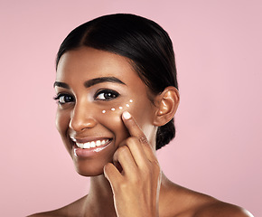 Image showing Smile, skincare and face of woman with cream in studio isolated on a pink background. Dermatology, creme cosmetics and portrait of happy Indian female model apply moisturizer lotion for healthy skin.