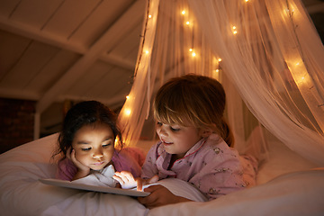 Image showing Bed, night and girls with a tablet, movie and playing games with happiness, online reading and relax. Female children, happy kids and young people in a bedroom, evening and technology for fun and app