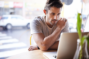 Image showing Laptop, thinking and man freelancer working in a restaurant as remote work in a cafe or coffee shop and reading an email. Internet, website or serious male person or consumer blogging online in store