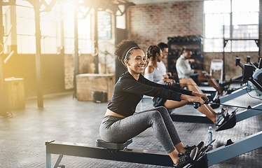 Image showing Group, rowing machine and training in gym, class or fitness workout, exercise or cardio, row team and practice. People, healthy athlete and challenge on sport equipment, row crew and sports club