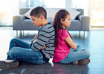 Image showing Angry, brother and sister in home living room, fighting or argument, conflict or problem. Anger, children and kids sitting with arms crossed on floor with their backs together, frustrated and cross.