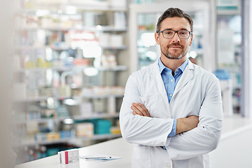 Image showing Healthcare, crossed arms and portrait of a male pharmacist standing in a pharmacy clinic. Pharmaceutical, medical and mature man chemist with confidence by the counter of medication store dispensary.