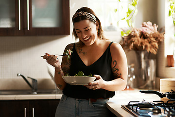 Image showing Woman, diet and person eating salad in her home kitchen and is happy for a meal with nutrition or healthy lunch. Smile, food and young female vegan in her apartment or house and eat vegetables