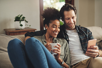 Image showing Home, relax and interracial couple on a couch, smartphone and happiness with connection, mobile app and social media. Partners, happy man and woman with a cellphone, communication and online reading