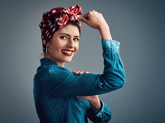 Image showing Strong, pinup girl and flexing muscle portrait of a woman in studio for beauty, power and fashion. Happy female person show bicep on grey background for motivation, freedom and retro or vintage style