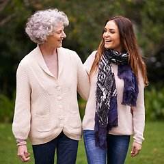 Image showing Smile, park and woman with elderly mother together on a outdoor vacation or holiday bonding in happiness. Retirement, women and young happy female person in conversation and laughing with mom