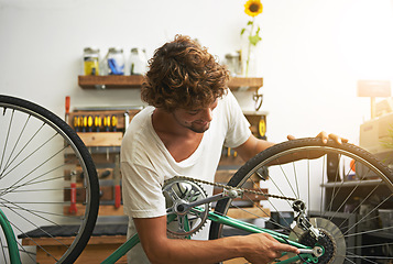 Image showing Repair, bicycle and man in a workshop, happy and prepare for training, exercise and competition. Male biker, person and human fixing wheel, cycling and problem solving with maintenance and inspection