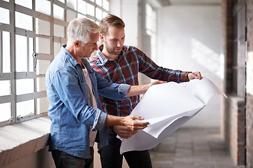 Image showing Architect, teamwork and holding blueprint for reading, planning or analysis of real estate development. Men, paper and design at property, construction site or building with talk, discussion or help