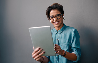 Image showing Woman, portrait and tablet with earphones by wall background with smile, music or video on internet. Gen z girl, earpods and mobile touchscreen with happiness for sound, audio and social media app