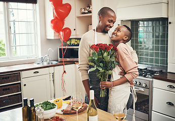 Image showing Flowers, love and valentines day with a black couple in the kitchen for a romantic celebration together. Food, gift or romance with a man and woman bonding in their home during a special event