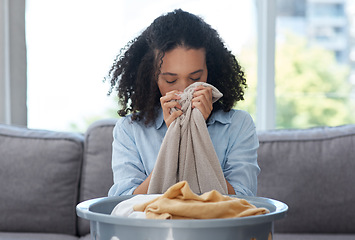 Image showing Smelling laundry, fresh and a woman on the sofa with a basket for organizing linen and clothes. Comfort, house and young cleaner with satisfaction from the smell of clean clothing in the living room