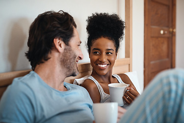 Image showing Happy interracial couple, bed and coffee in relax for morning, bonding or breakfast at home. Man and woman smiling for tea, conversation or talk on relaxing weekend or holiday together in the bedroom