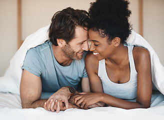 Image showing Happy interracial couple, bed and intimate morning in relax or bonding relationship at home. Man and woman smiling in joyful happiness for love, affection or relaxing weekend together in the bedroom