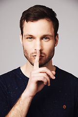 Image showing Man, secret and portrait with silence, hand and finger emoji sign in a studio. Isolated, gossip and whisper of a young male model face with confidential, lips and person with privacy and stop gesture