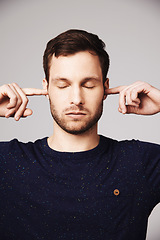 Image showing Man, quiet and block ears in studio with thinking, peace and mindfulness to relax by white background. Isolated guy, model and fingers to stop noise, focus and mindset with memory, idea and backdrop