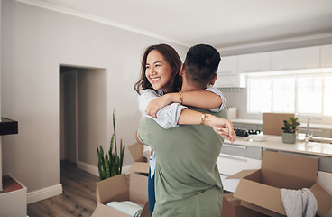 Image showing Property, happy couple moving into their new home and boxes in living room. Happiness or smiling, mortgage or homeowners and people hugging celebrating with their new house or apartment together
