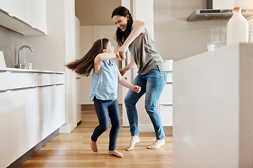 Image showing Happy, dance and a child with a mother in the kitchen, bonding and quality time together. Smile, laughing and a mom teaching her daughter with dancing, love and happiness with fun in a house