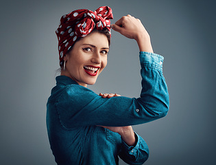 Image showing Pinup girl, strong and flexing muscle portrait in studio for beauty, women power and fashion. Happy female person show bicep on a grey background for motivation, freedom and retro or vintage style