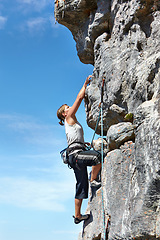 Image showing Rock climbing, explore and challenge with woman on mountain for adventure, travel and fitness. Strong, freedom and blue sky with climber training in nature for courage, safety and workout mockup