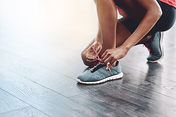 Image showing Sneakers, fitness and person tie laces to start exercise, workout or wellness sport in a gym for health performance. Shoes, space and hands of a healthy woman or runner ready for training or sports