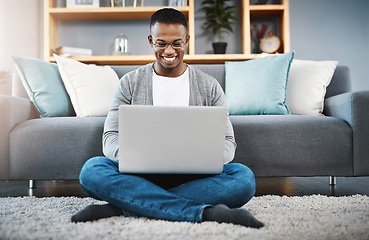 Image showing Laptop, floor and happy man with work from home, online research and typing in living room for career opportunity. Relax, carpet and young african person working on computer or technology in lounge