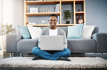 Image showing Floor, laptop and portrait of man for home, online research and happy freelancer job in living room with remote work opportunity. Smile, carpet and young african person on computer or technology