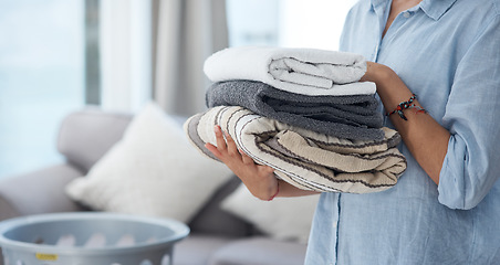 Image showing Hands, laundry and spring cleaning with a woman holding a pile of fresh towels in the living room of her home. Fabric, hospitality and washing with a female cleaner in her apartment for housework