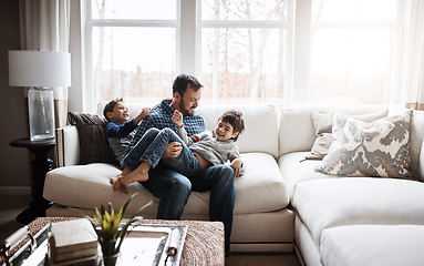 Image showing Father, boy children at family home and playing in living room, fun and carefree with love, energy and happiness. Man play with kids on sofa, crazy and playful with laughter and joy in the house