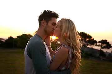 Image showing Couple kissing, nature and trees in sunset with love, romance and date on adventure, travel or honeymoon. Man, woman and kiss with hug, care and outdoor for safari, travel or travel in countryside