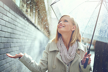 Image showing Smile, woman and raindrops in the city with umbrella, freedom and happiness on holiday. Winter weather, raining and urban street with a young female person on a sidewalk and vacation outdoor