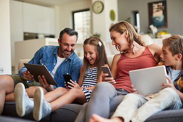 Image showing Technology, streaming and a happy family on the sofa for internet, social media and communication. Smile, bonding and a mother, father and children with a tablet and phone for online games at home