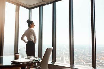 Image showing Business woman, office window and thinking of ideas, plan or vision in city building. Professional female entrepreneur person with hands on hips for motivation or inspiration for corporate career