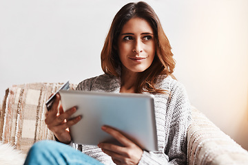 Image showing Idea, tablet and online customer with a woman shopping using a credit card on a sofa in the living room at home. Ecommerce, finance and internet banking with a young female shopper in her house