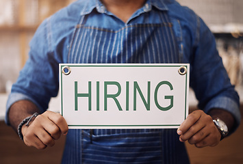 Image showing Closeup, hiring sign and man advertising employment in shop, store and notice of recruitment opportunity. Hands, banner and recruiting poster for outsourcing, vacancy and job hire in small business