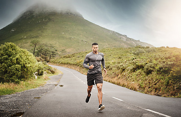 Image showing Man, running and training in nature in street for exercise, wellness and music with commitment for health. African male runner, listening and audio for focus, mindset and outdoor with workout on road